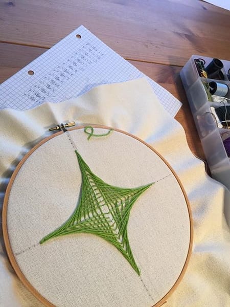 embroidery with green string of curves formed with straight lines