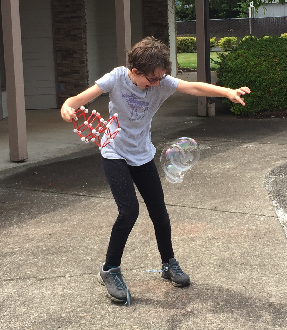 a student playing with zome tools to make bubbles with joy