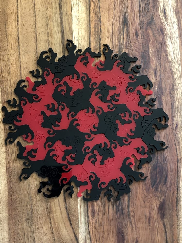 a laser cut rotation tessellation made with black and red tiles