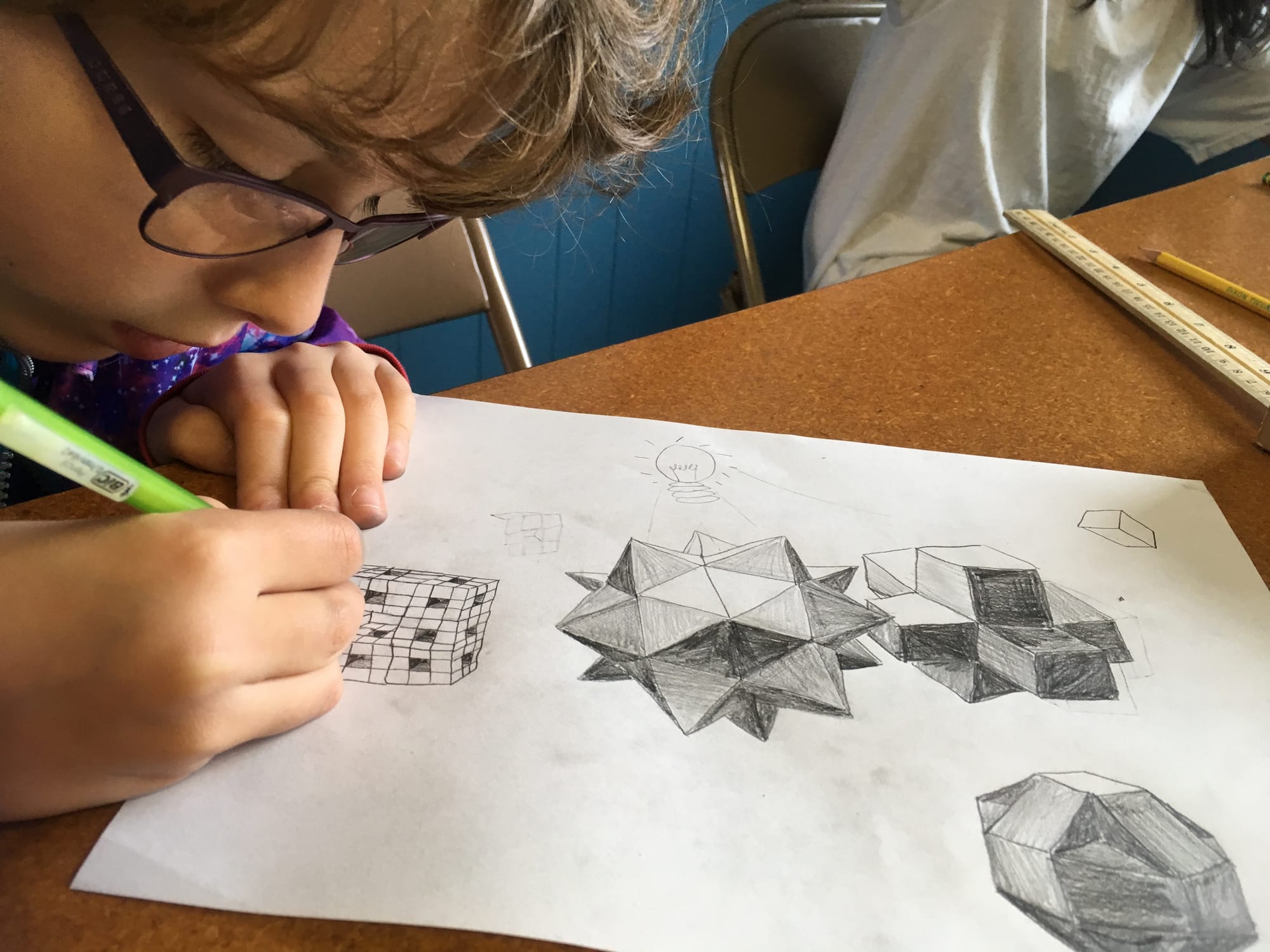 a person sketching geometric shapes