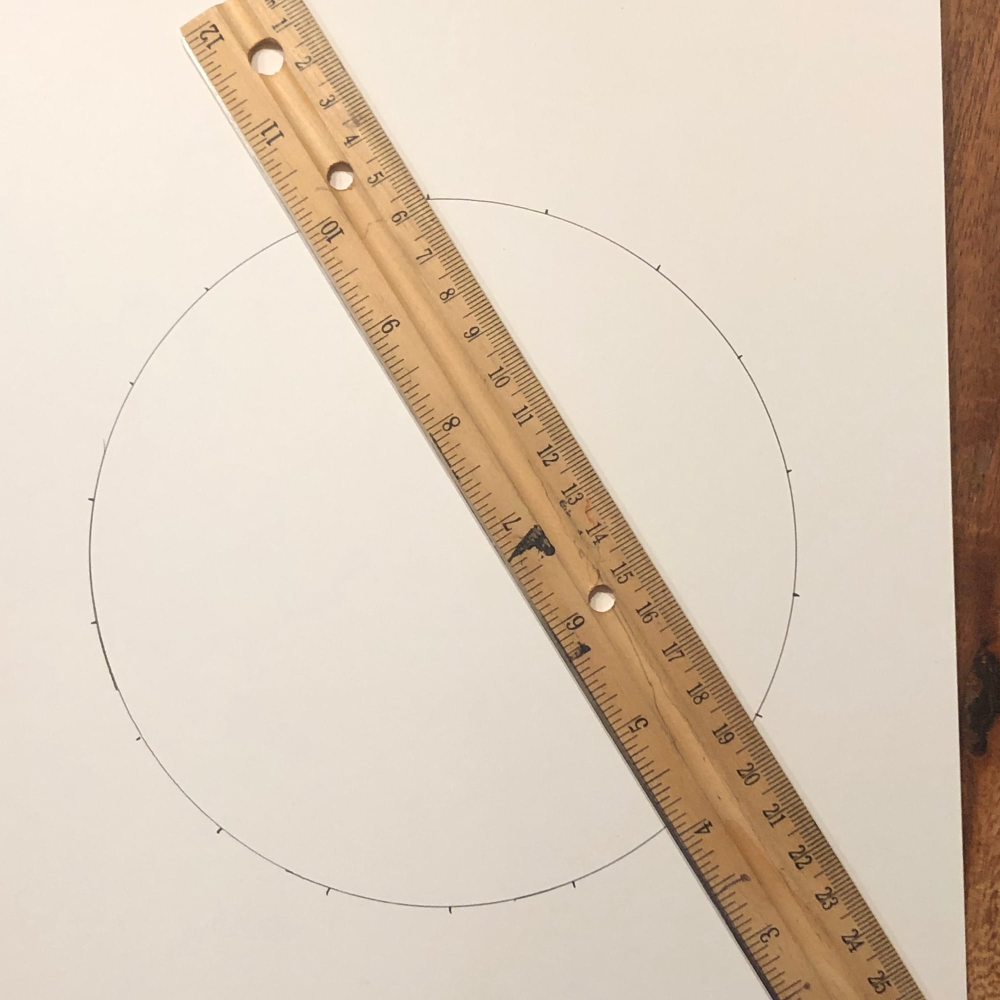 a circle with tick marks and a ruler connecting two of them