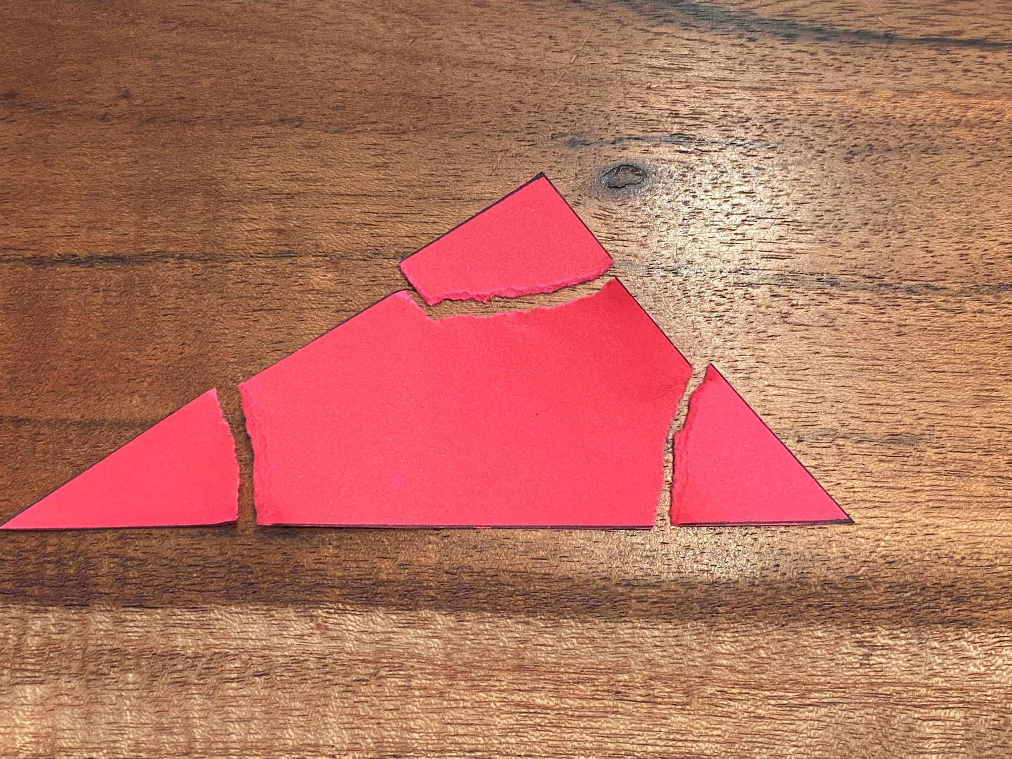 a red triangle paper with the corners torn and sitting next to it