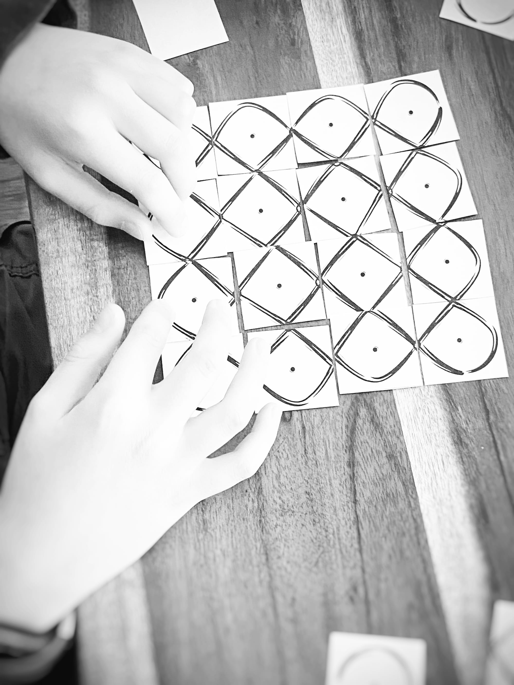 paper kolam tiles with a childs hands putting them together